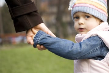 A child holding their parent's hand